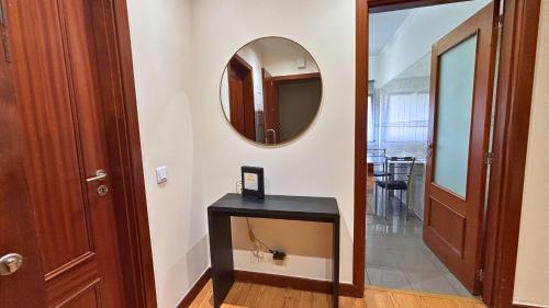 een hal met een spiegel en een zwarte tafel bij Dragoeiro Duplex by Sam Houses in Ribeira Brava