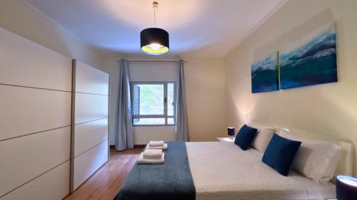 een slaapkamer met een groot bed en een raam bij Dragoeiro Duplex by Sam Houses in Ribeira Brava