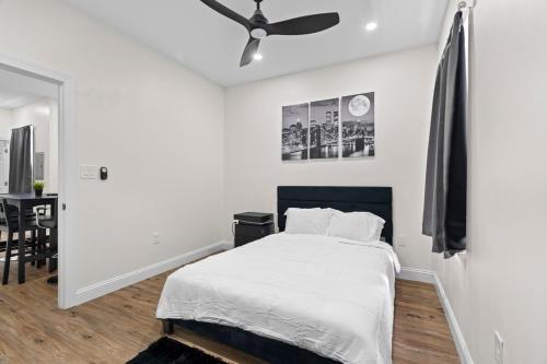 a white bedroom with a bed and a ceiling fan at Modern 2 bedroom 1 bath unit 2 Near Airport, Xfinity Arena and Eagles Stadium in Philadelphia
