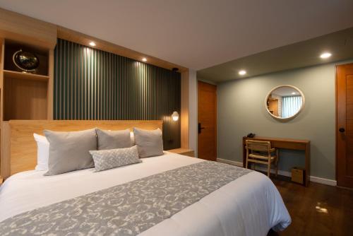 a bedroom with a large white bed and a mirror at Hotel Boutique Casa Flor de Café in Mexico City
