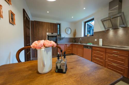 a kitchen with a vase with flowers on a table at Wald Villa Schönau in Schönau an der Brend
