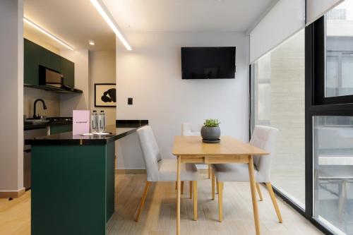 a kitchen and dining room with a table and chairs at Lamartine 205 by Wynwood House in Mexico City