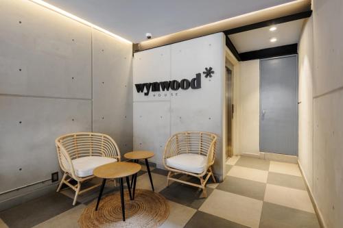 a lobby with two chairs and a sign on the wall at Lamartine 205 by Wynwood House in Mexico City