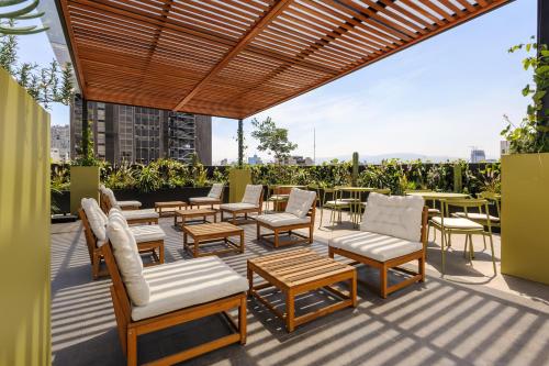 a patio with chairs and tables on a building at Colima 340 by Wynwood House in Mexico City