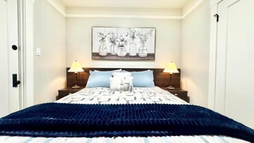 a bedroom with a large blue bed with two lamps at Downtown Historic Spanish Bungalow, with Parking in San Jose