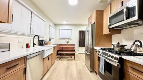 a kitchen with wooden cabinets and white counter tops at Downtown Historic Spanish Bungalow, with Parking in San Jose