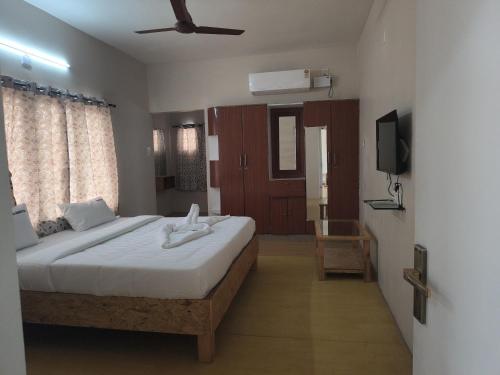 a bedroom with a large bed and a television at Pks Grand Park in Coimbatore