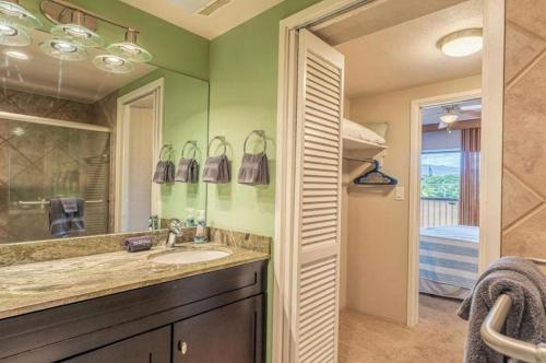 a bathroom with a sink and a mirror and a bedroom at Kona Plaza#409 in Kailua-Kona