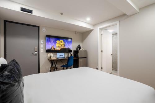 a bedroom with a bed and a desk with a computer at Olympia Hotel by Lodgo in Montréal