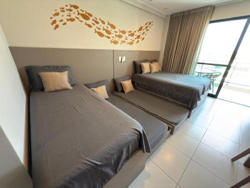 سرير أو أسرّة في غرفة في FLAT DE LUXO vista piscinas, Praia de Muro Alto - Malia Beach