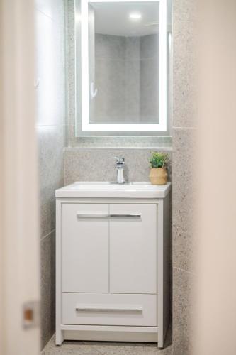 a bathroom with a white sink and a mirror at Olympia Hotel by Lodgo in Montréal