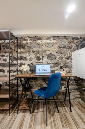 a desk with a blue chair in front of a stone wall at Olympia Hotel by Lodgo in Montréal
