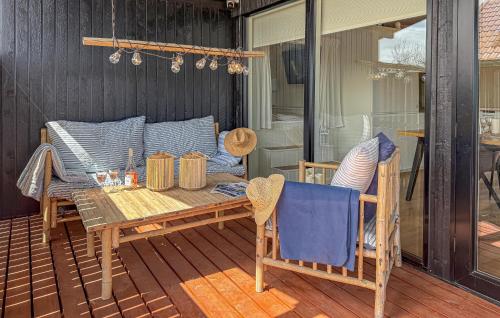 a patio with a table and chairs on a deck at 3 Bedroom Amazing Home In Sjølund in Binderup Strand