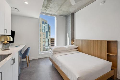 a bedroom with a bed and a large window at Placemakr Downtown Phoenix in Phoenix
