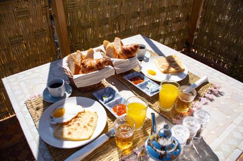 a table with a breakfast of eggs and bread at Sun Hostel in Marrakech