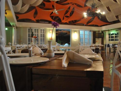 a dining room with tables and white chairs at Hotel Rey in Concepción de La Vega