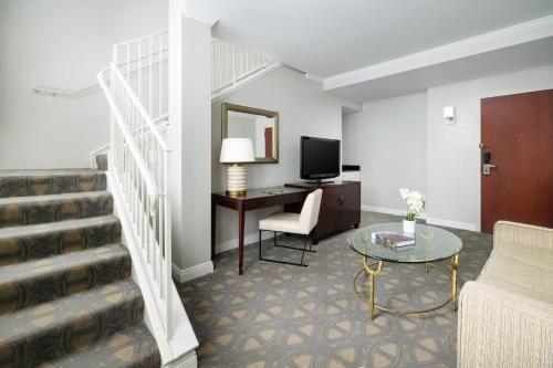 a living room with a couch and a desk with a television at Riverfront Hotel New Orleans in New Orleans