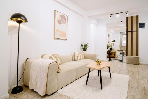 a white living room with a couch and a table at My Happy Place - Craiova in Craiova