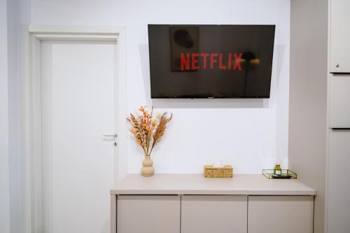 a living room with a tv on a white wall at My Happy Place - Craiova in Craiova