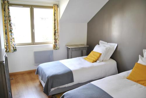 1 dormitorio con 2 camas y ventana en Cottage Les Quatre Saisons, en Giverny