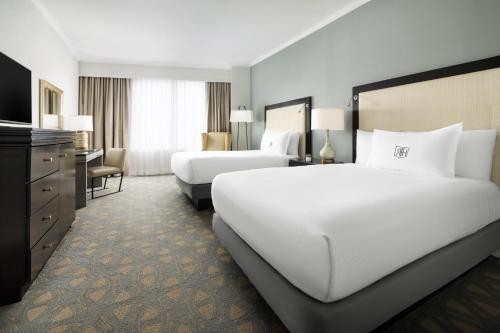 a hotel room with two beds and a television at Riverfront Hotel New Orleans in New Orleans