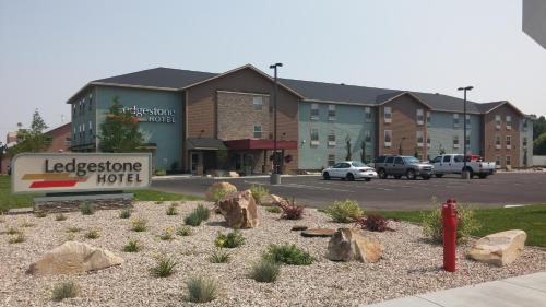 a sign for a hotel in front of a building at Ledgestone Suites Hotel Vernal in Vernal