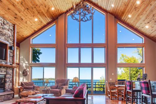 a large living room with large windows at Spacious Leech Lake Home on 2 Private Acres, 200' of lake shore 15 Minutes to Walker with boat lift, dock, swimming, fire pit in Walker