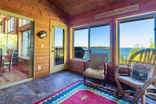 a screened in porch with a chair and windows at Spacious Leech Lake Home on 2 Private Acres, 200' of lake shore 15 Minutes to Walker with boat lift, dock, swimming, fire pit in Walker