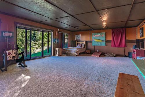 a large living room with a bed and a table at Spacious Leech Lake Home on 2 Private Acres, 200' of lake shore 15 Minutes to Walker with boat lift, dock, swimming, fire pit in Walker
