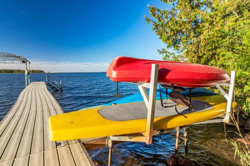 a boat on the water next to a dock at Spacious Leech Lake Home on 2 Private Acres, 200' of lake shore 15 Minutes to Walker with boat lift, dock, swimming, fire pit in Walker