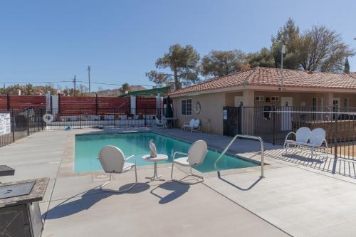 una piscina con sedie e tavolo e una casa di Shasta Trailer- Vintage Charm, Modern Comfort Pool a Yucca Valley
