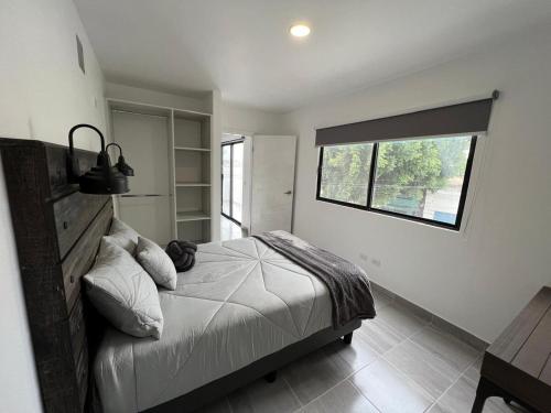 a bedroom with a large bed with a window at Depa en La Cienega in Tijuana