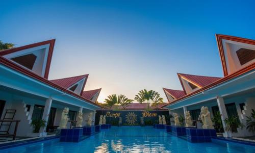 a view of the courtyard of a resort with a swimming pool at Carpe Diem Villas & Resort in Puerto Princesa City