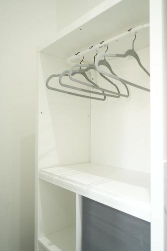 a white cabinet with hangers in it at Concept Rooms in Enfield