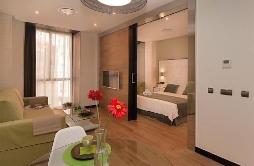 a hotel room with a bed and a living room at Apartamentos Suites Oficentro Deluxe in Málaga