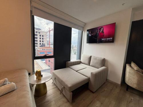 a living room with a couch and a large window at Republica del Salvador Coliving Ecuador XOE in Quito