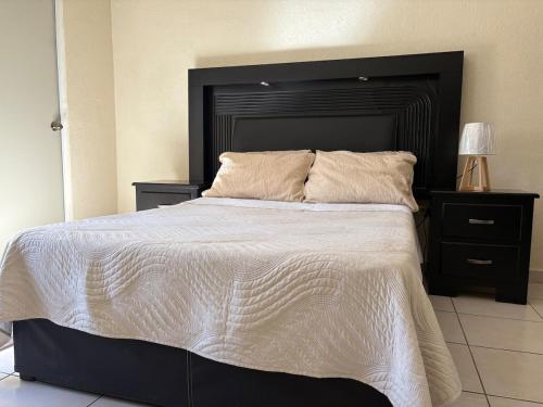 a bedroom with a large bed with a black headboard at Casa Sofia de una planta in Hermosillo