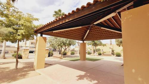 a pavilion with a wooden roof on a sidewalk at Casa Sofia de una planta in Hermosillo