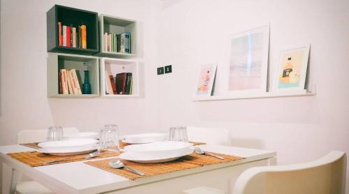 a white table with two white plates and books at Luxury Suite Vitruvio 55 in Formia