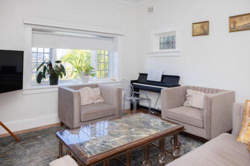 a living room with a table and a piano at Private BB near airport, beach, and activities in Sydney