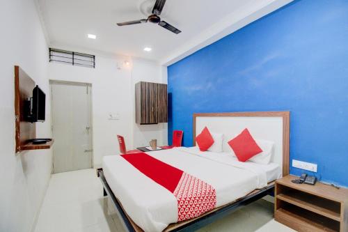 a bedroom with a bed and a blue wall at Hotel O Abhimaani Inn in Bengaluru