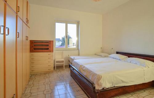 1 Schlafzimmer mit 2 Betten, einer Kommode und einem Fenster in der Unterkunft Amazing Apartment In Santa Maria Di Castell in Santa Maria di Castellabate