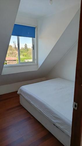 a small bedroom with a bed and a window at Parcela en Mallarauco in Melipilla