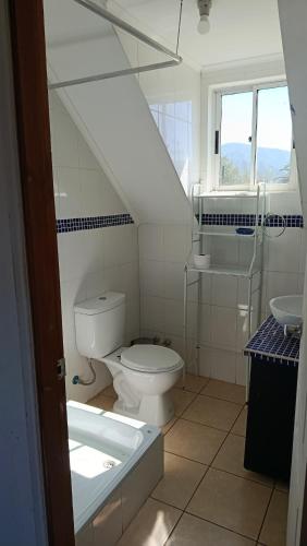 a white bathroom with a toilet and a sink at Parcela en Mallarauco in Melipilla