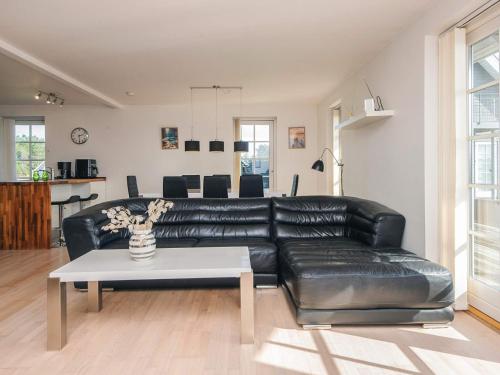 a black leather couch in a living room with a table at 5 star holiday home in Rømø in Sønderby
