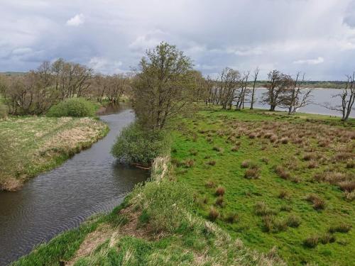 a river in the middle of a field with grass at 10 person holiday home in Ry-By Traum in Ry