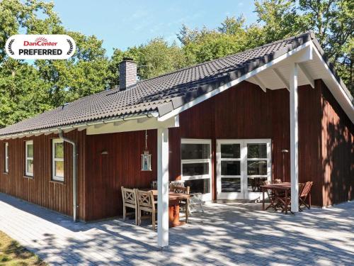 a wooden cabin with a table in front of it at 6 person holiday home in Hadsund-By Traum in Odde