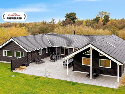 a large house with a patio in front of it at 22 person holiday home in Idestrup in Marielyst