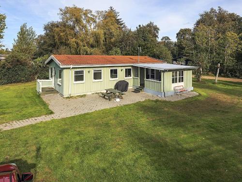 a small green shed with a picnic table in a yard at 8 person holiday home in Stege-By Traum in Stege