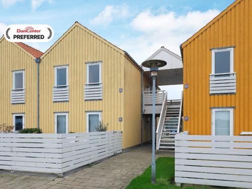 a yellow building with a staircase in front of it at 6 person holiday home in Rudkøbing-By Traum in Rudkøbing